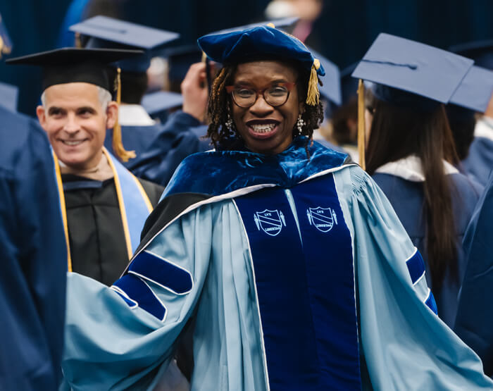 Dr. Vanessa Perry processes into the ceremony, additional faculty and students in the background